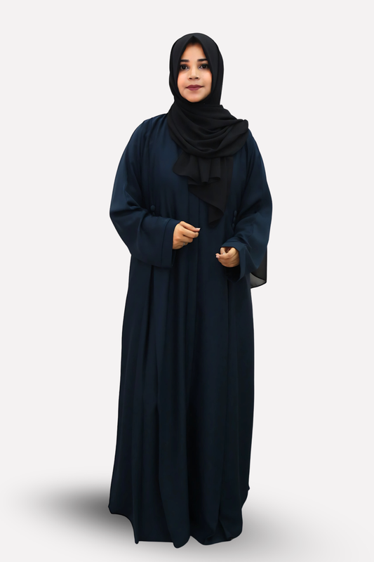 Woman wearing a long dark blue abaya with a matching hijab on a white background