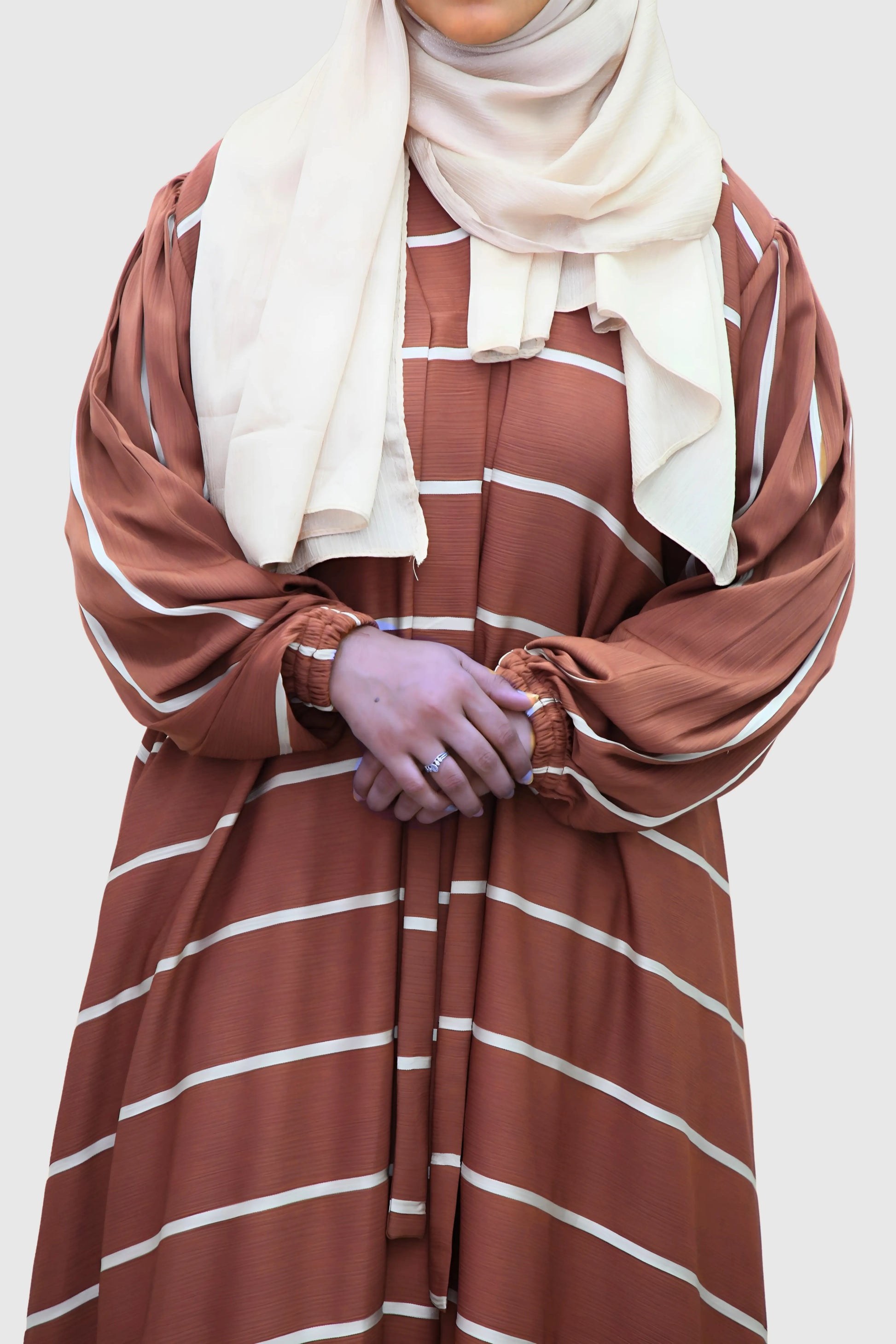 Modern Muslim girl in premium abaya and matching hijab standing with confidence.