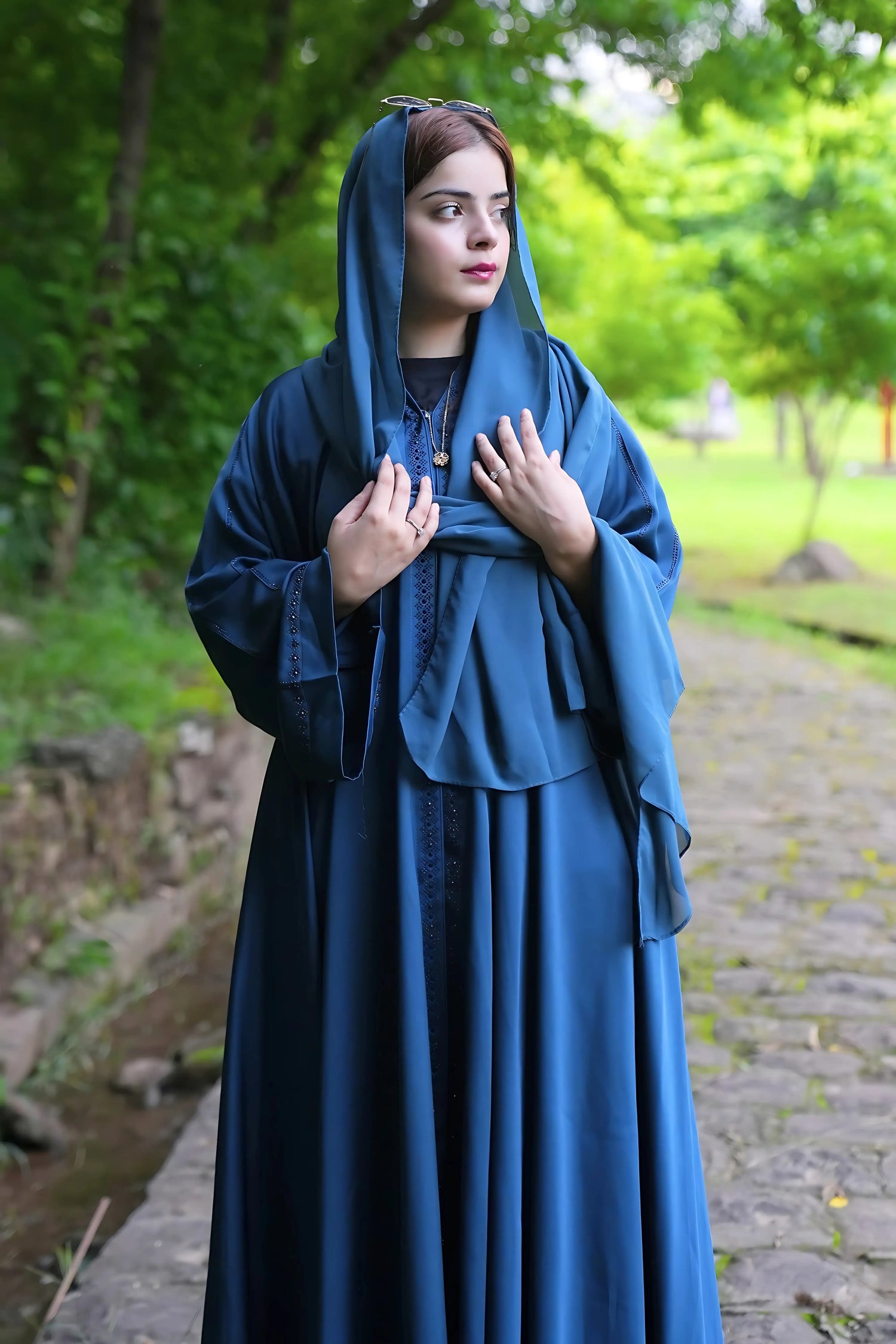 a girl wearing NIDA fabric premium quality abaya with matching hijab standing in a park