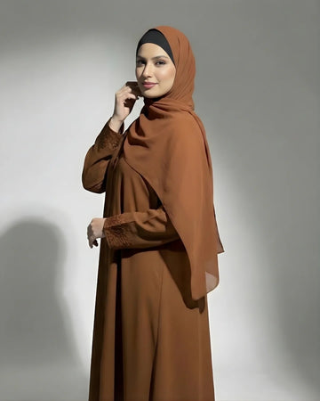 a girl wearing NIDA fabric premium quality abaya with matching hijab standing in a park