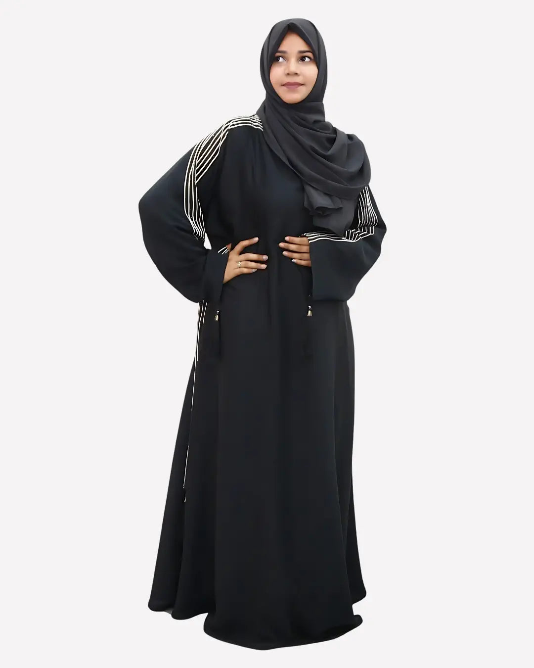 Woman wearing a black abaya with white embroidery on a white background