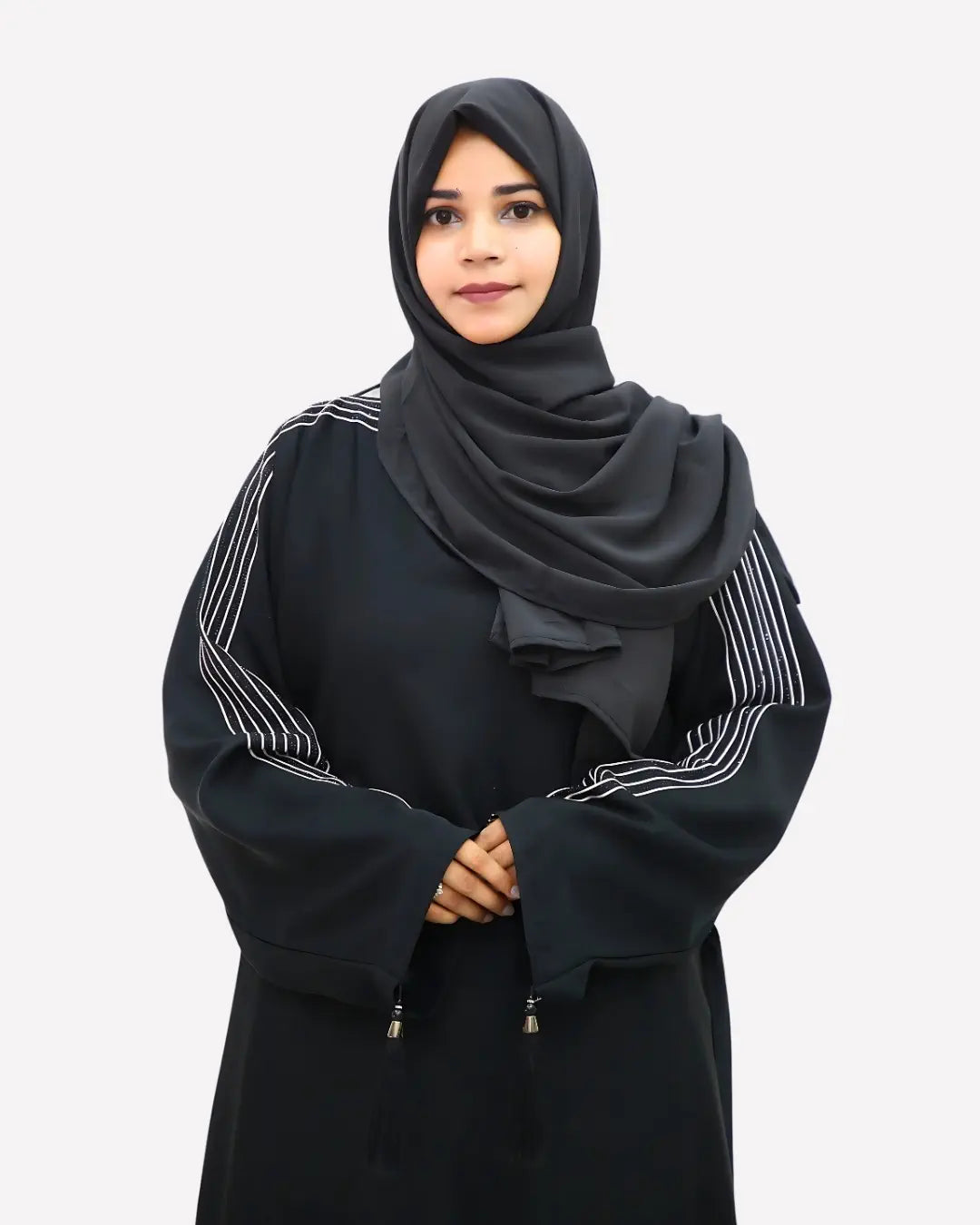 Woman wearing a black abaya with white embroidery on a white background
