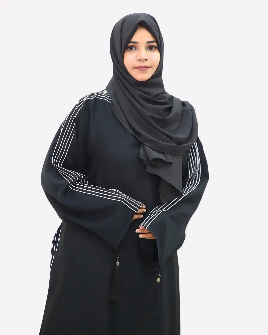 Woman wearing a black abaya with white stripes on a white background