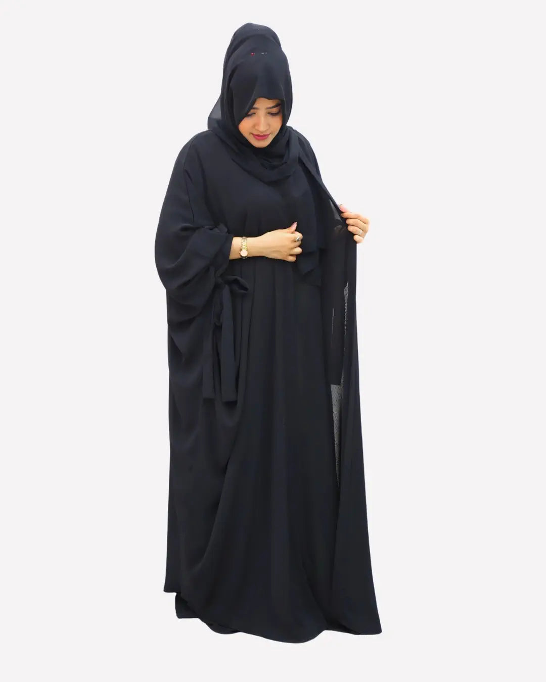 Woman wearing a black abaya on a white background