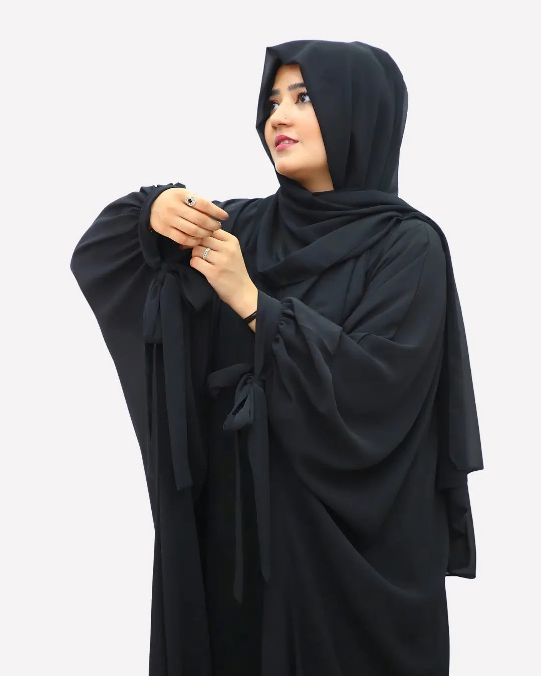Woman wearing a black abaya on a white background