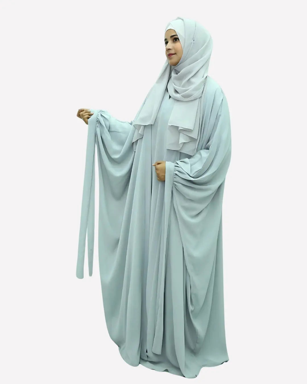 Woman wearing a light blue butterfly abaya on a white background