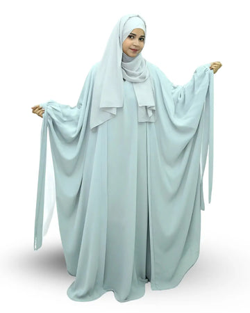 Woman wearing a light blue butterfly abaya on a white background