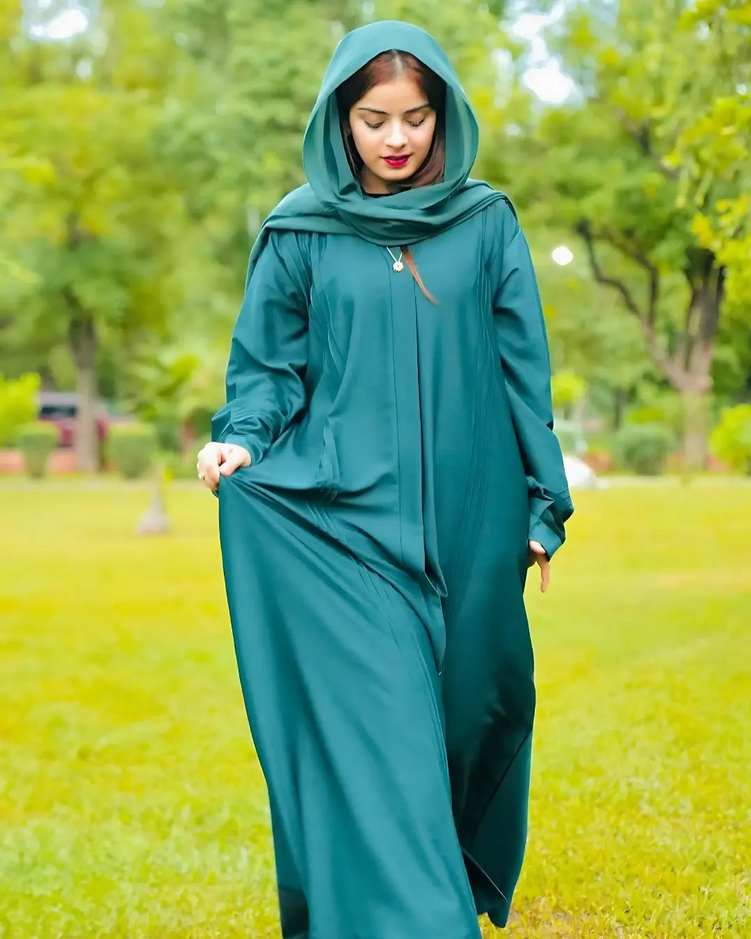 Woman wearing a premium qaulity abaya with a hijab in a park setting