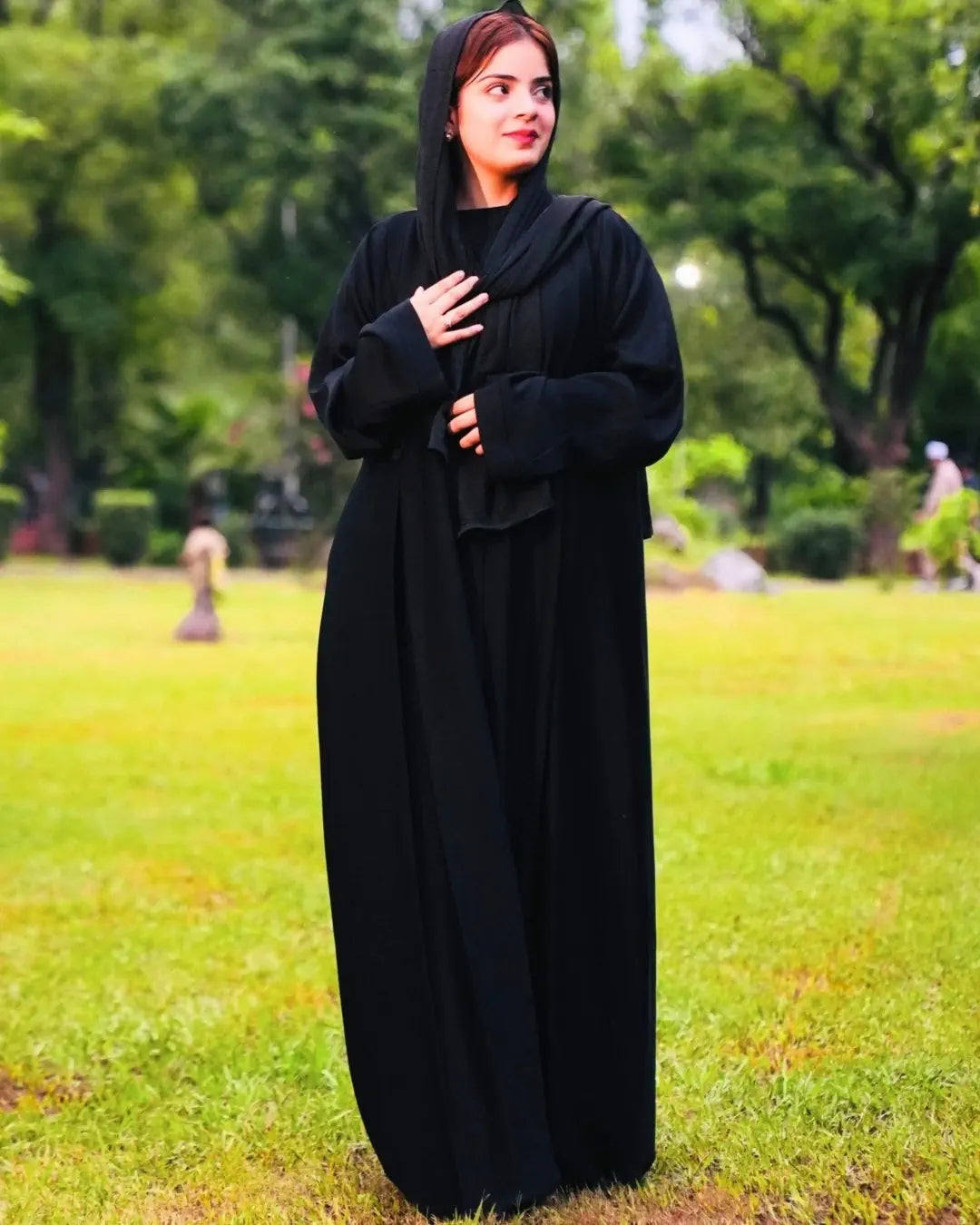 Woman wearing a black abaya in a park setting