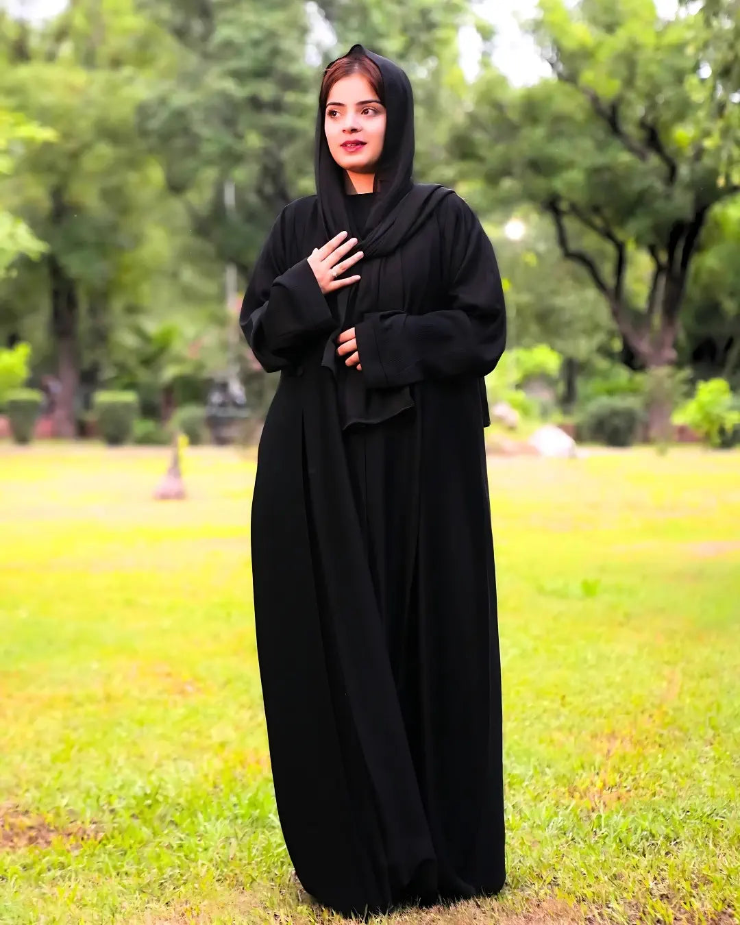 Person wearing a black abaya in a park setting