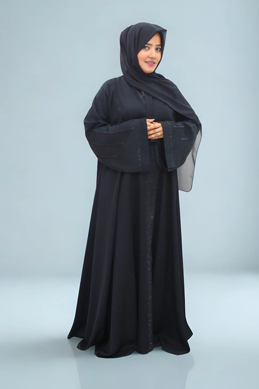 Woman wearing a black abaya on a light gray background