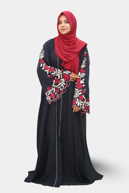 Woman wearing a black abaya with floral embroidery and a red hijab on a white background