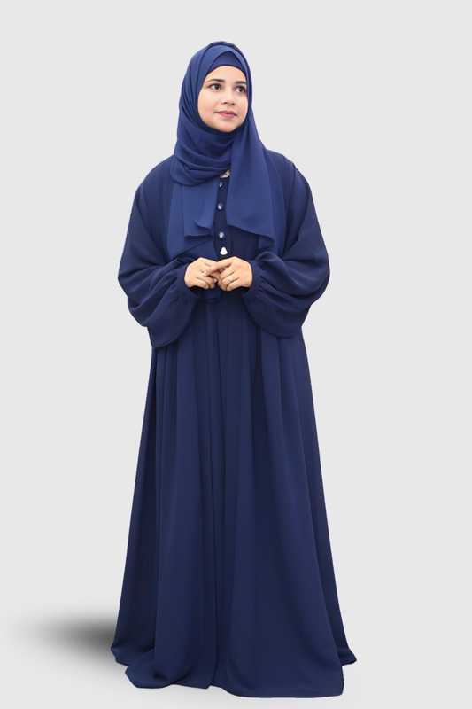 Woman wearing a long navy blue abaya with a matching hijab on a light gray background