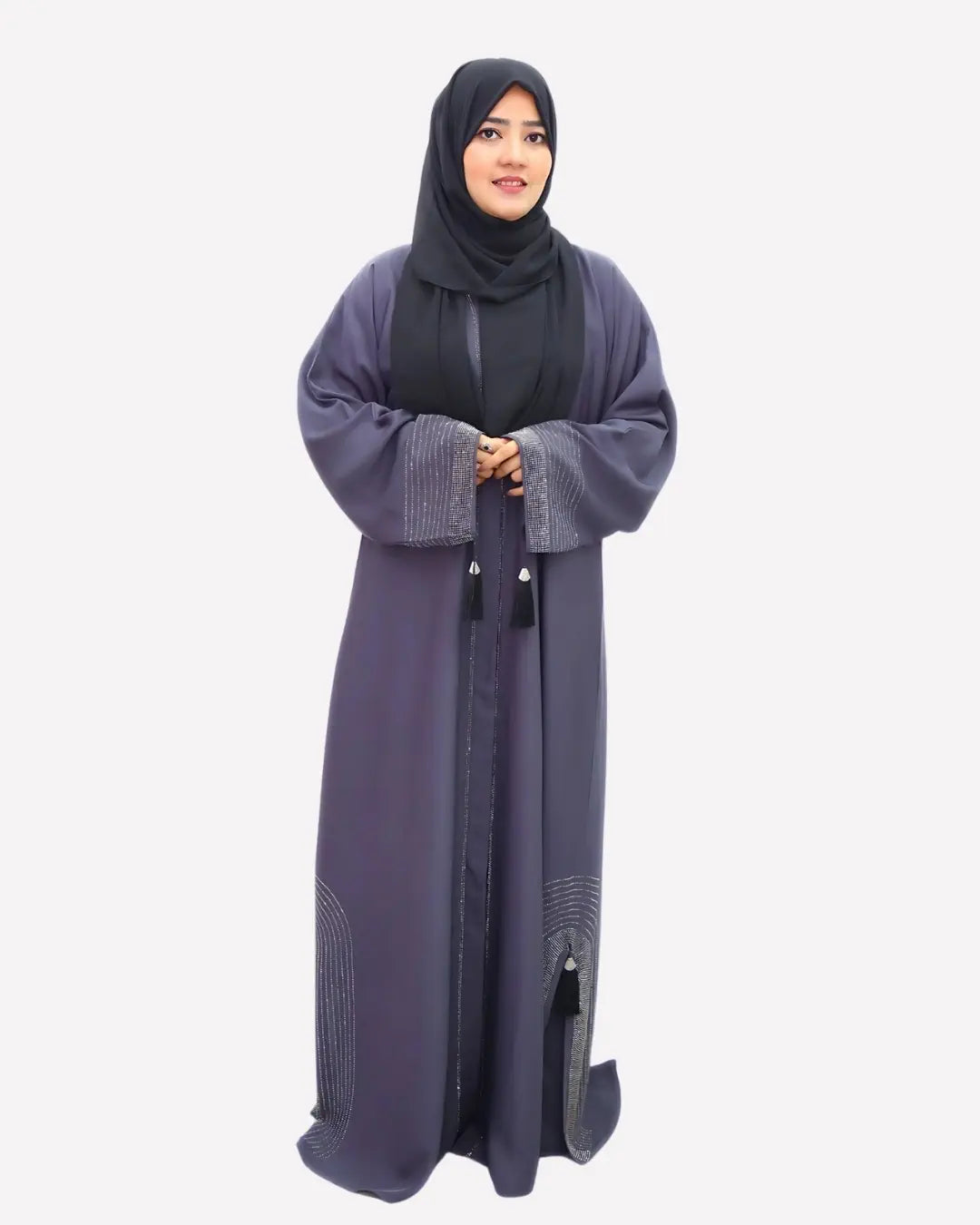 Woman wearing a long, dark gray abaya with a matching hijab on a white background