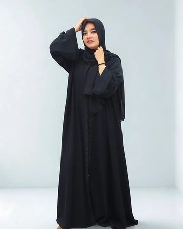 Woman wearing a black abaya against a white background