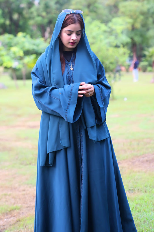 A girl wearing a premium quality abaya with hijab in a park
