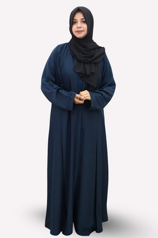 Woman wearing a navy blue abaya with a black hijab on a white background