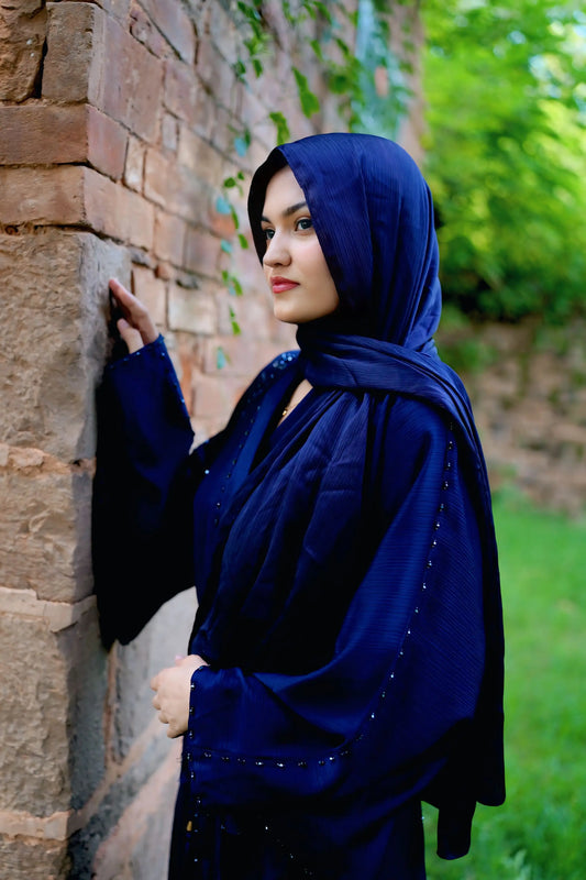 Muslim woman wearing a graceful abaya with a neatly draped hijab.