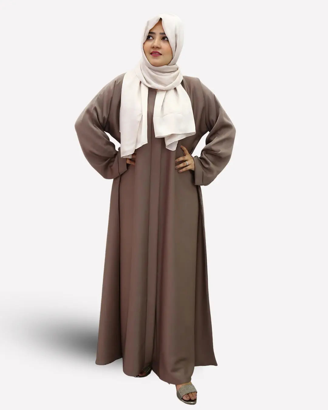 Woman wearing a long brown abaya and white hijab on a white background