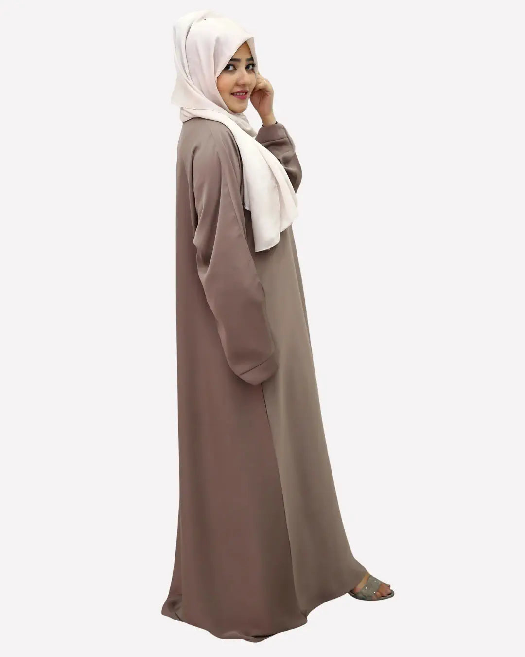 Woman wearing a long brown abaya and white hijab on a white background
