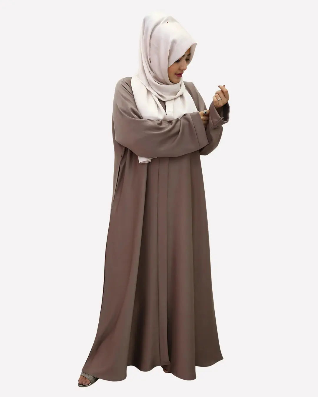 Woman wearing a long brown abaya and white hijab on a white background