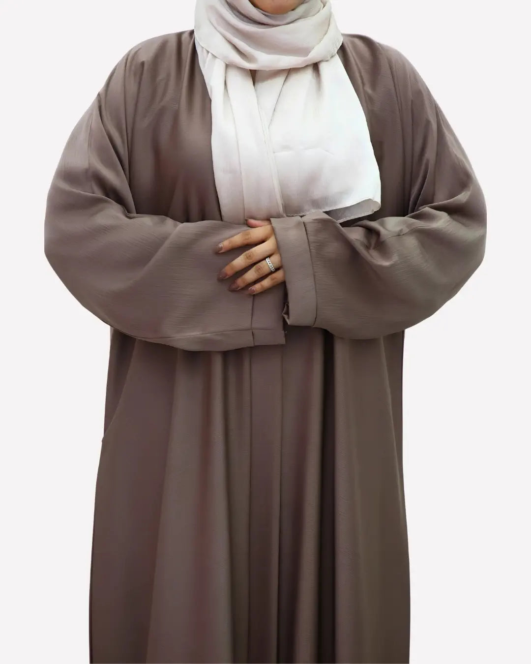 Person wearing a long brown abaya over with a white hijab on a plain background