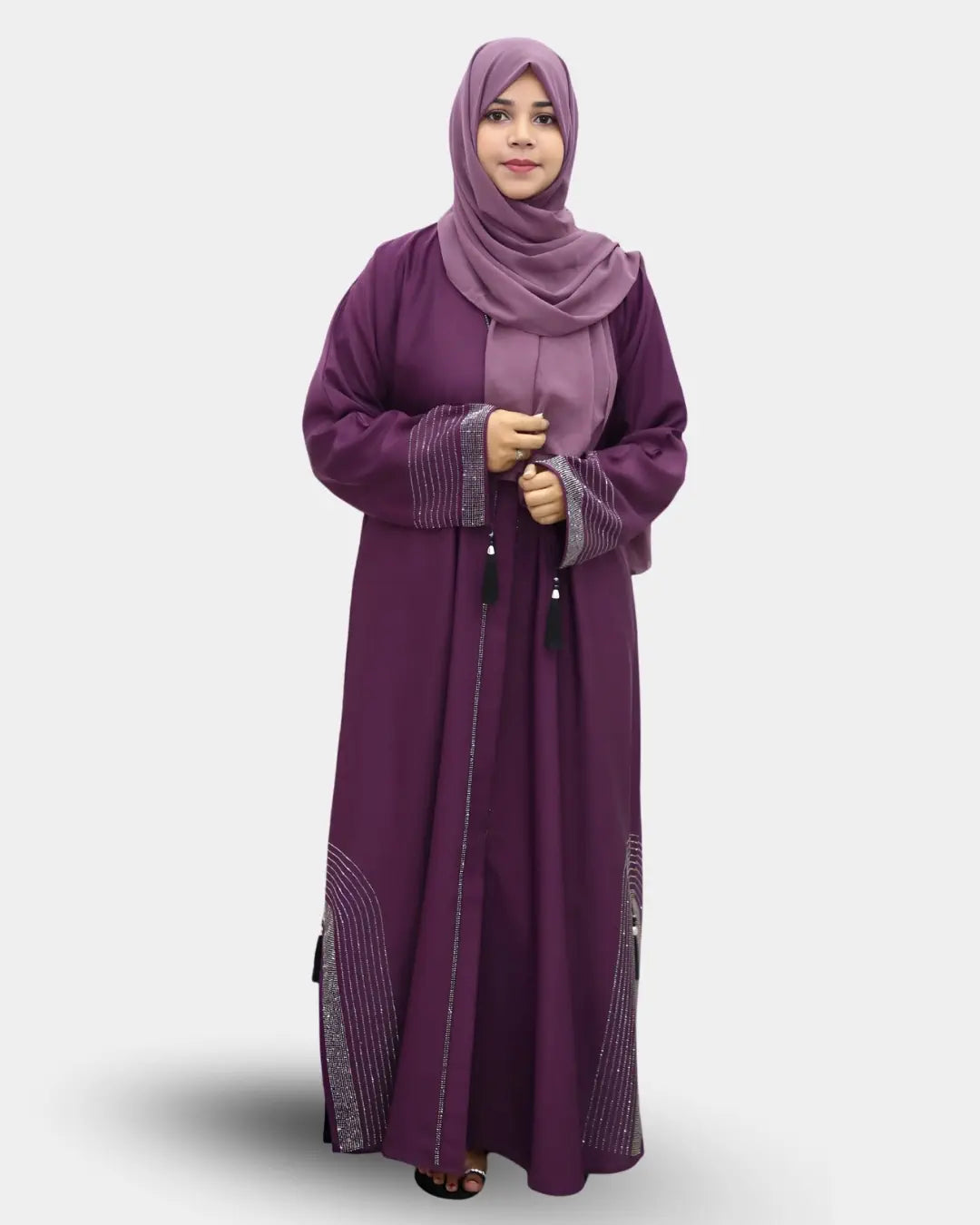 Woman wearing a long purple abaya with a matching hijab on a white background