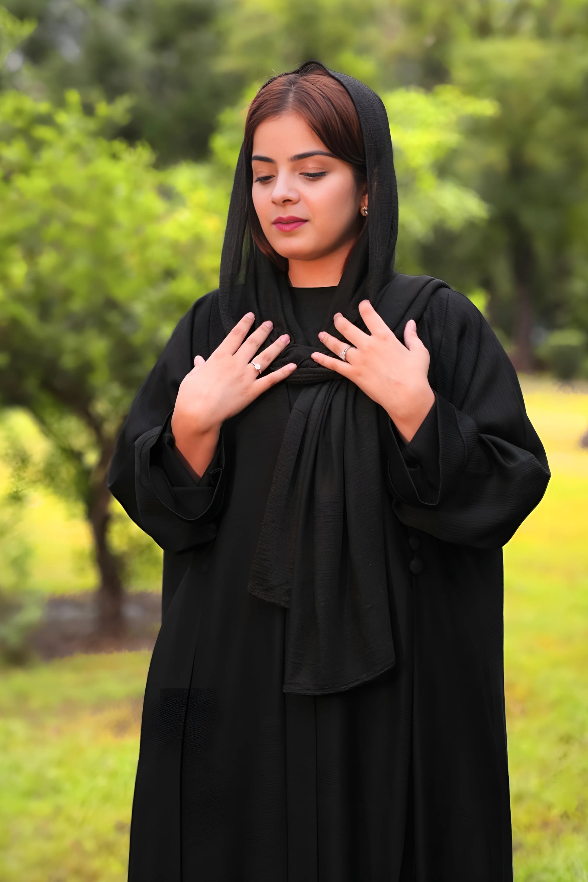 Woman wearing a black abaya in a park setting