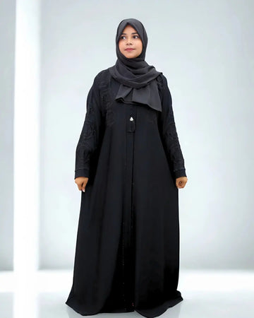 Woman wearing a black abaya and hijab on a white background
