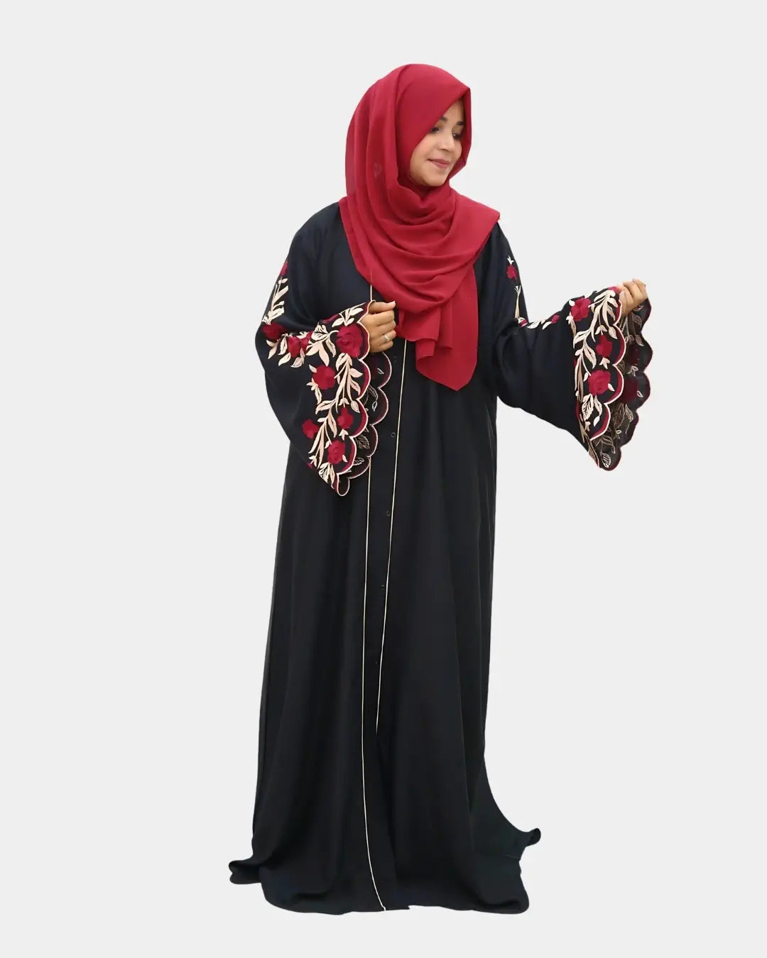 Woman wearing a black abaya with red embroidery and a matching red hijab on a white background