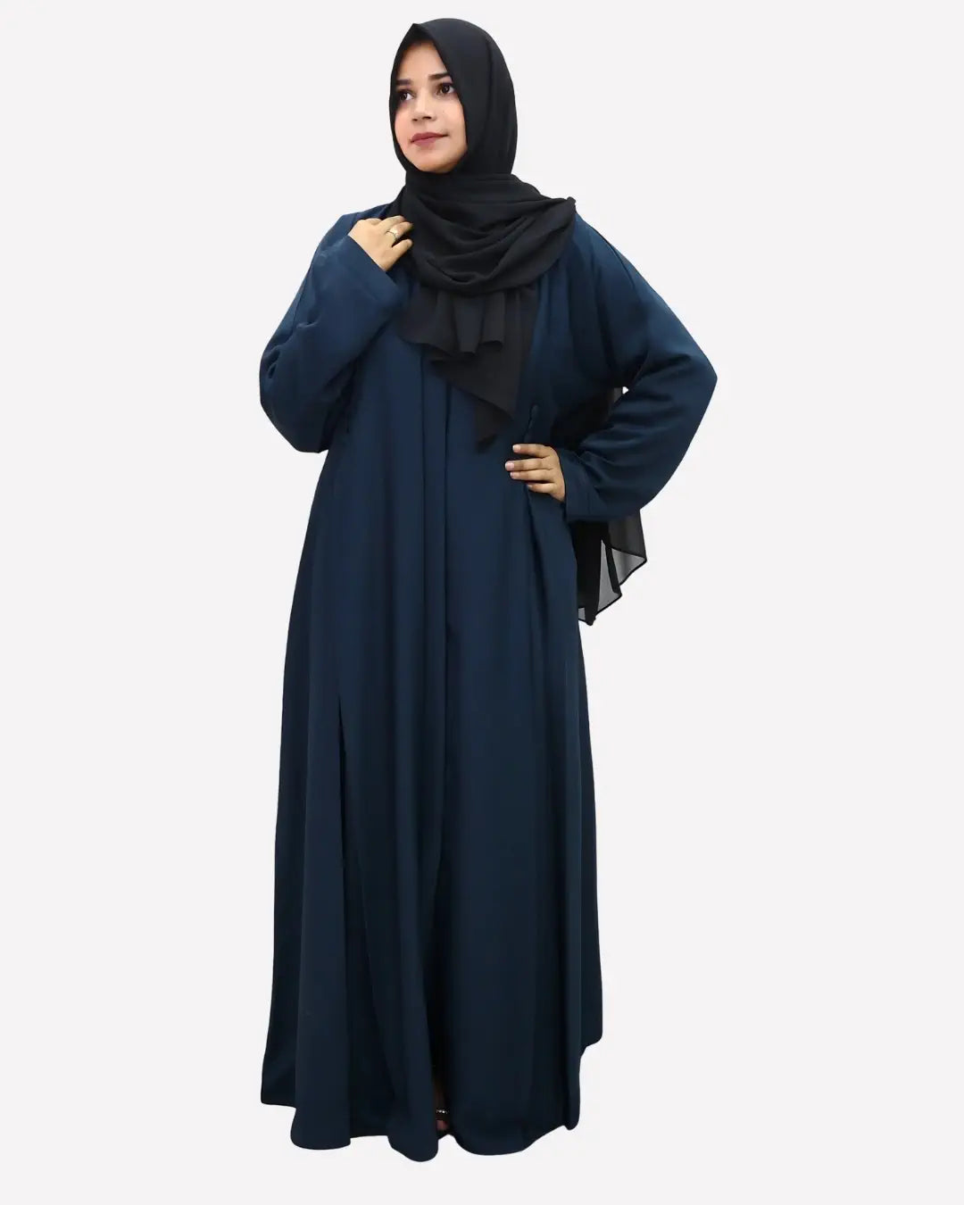 Woman wearing a long dark blue abaya with a black hijab on a white background