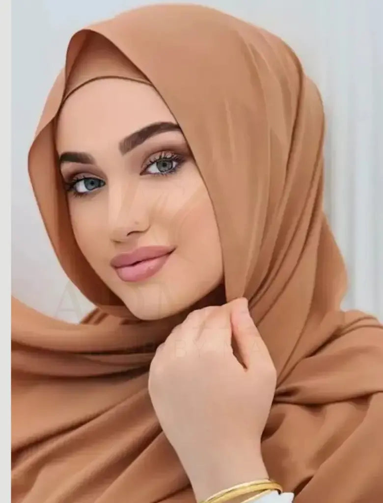 Woman wearing a brown hijab with a plain background