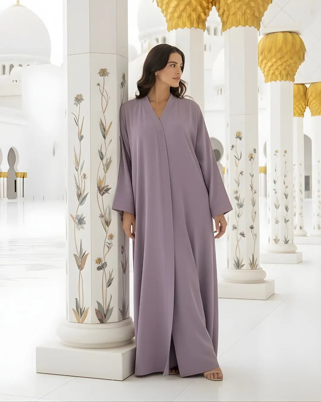 Woman in a long, light purple ABAYA standing in a mosque with white columns and gold accents.